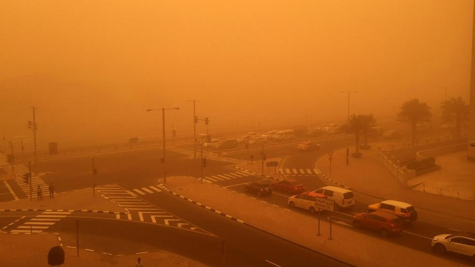 Autos y personas en medio de una tormenta de arena que afectó a la ciudad de Dubai el 2 de abril (Marwan Naamani).