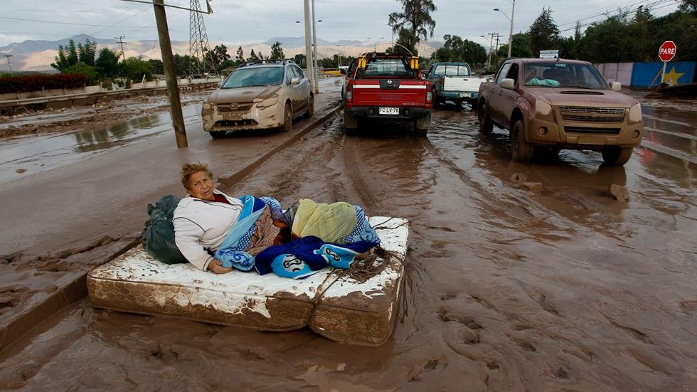 Una mujer descansa en un colchón en el barro luego de las inundaciones severas en Copiapó, Chile, el 26 de marzo (Marcelo Hernandez).