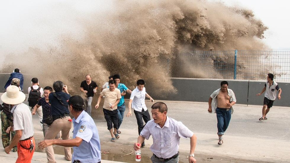La gente huye de las imponentes olas del río Qiantang el pasado 1 de septiembre, en Hangzhou, China (ChinaFotoPress).