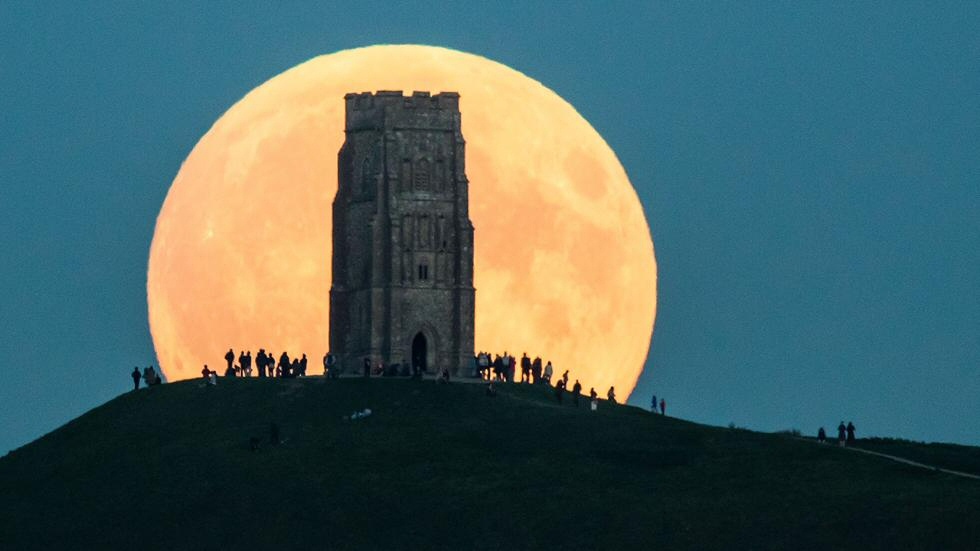 La superluna del 27 de septiembre asoma detrás de la colina Glastonbury Tor, en Inglaterra (Matt Cardy).